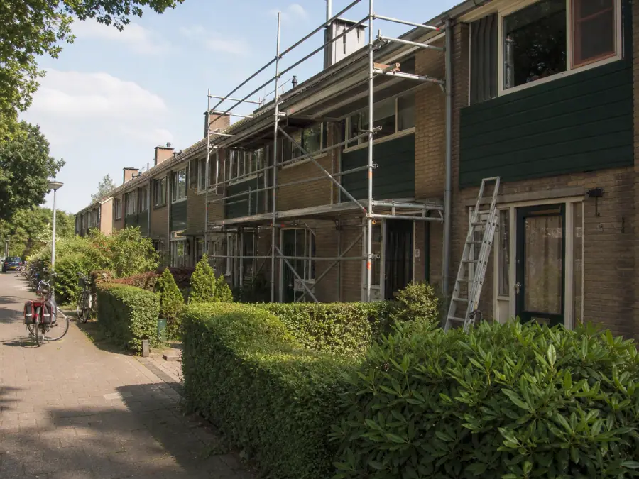 Rij jaren-70-woningen in Twente met een steiger tegen één voorgevel