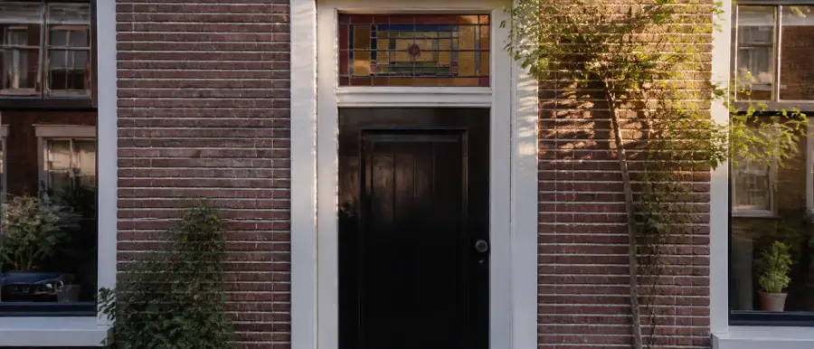 Vooroorlogse bakstenen gevel met massief metselwerk en een glas-in-loodbovenlicht